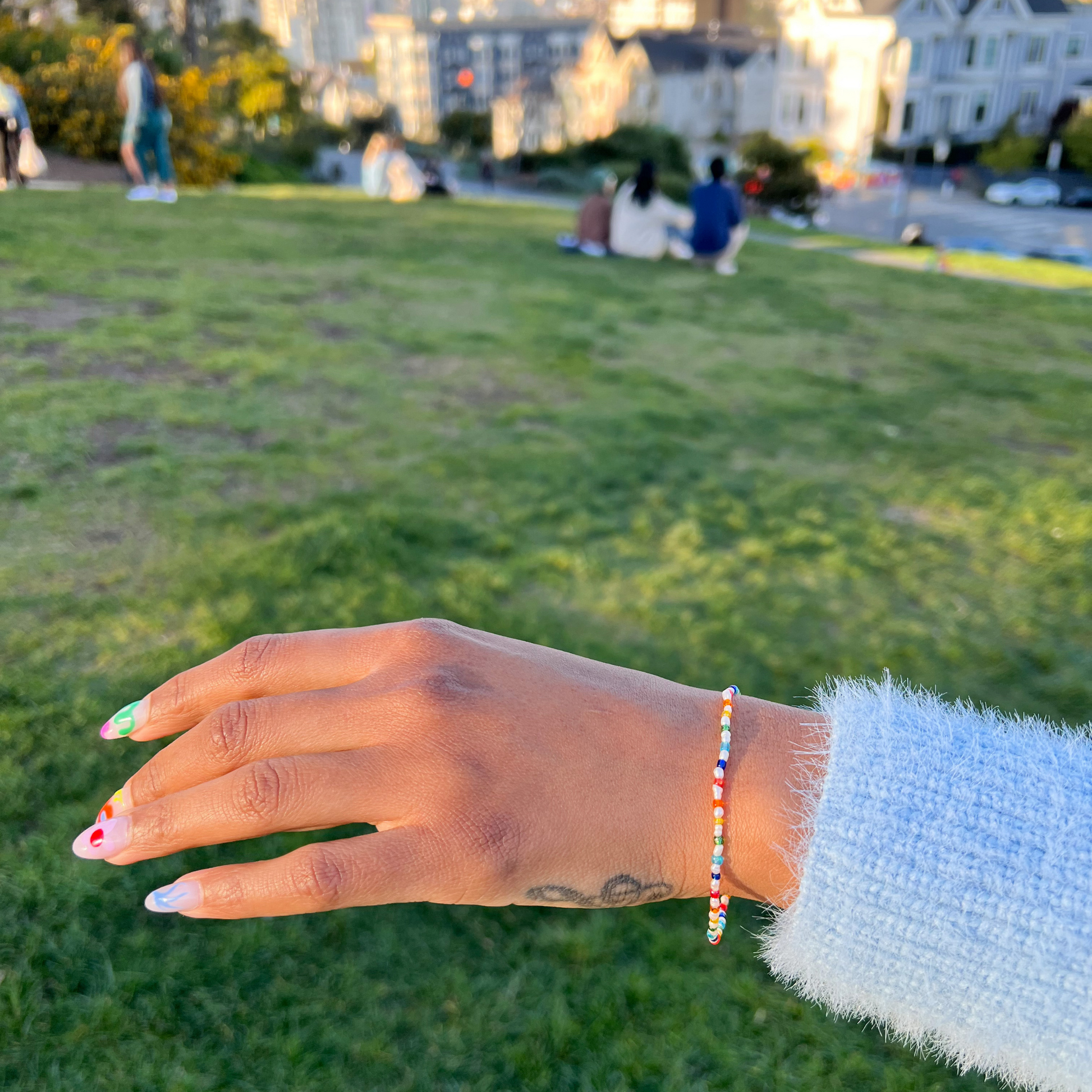 Roop jewelry rainbow baby pearl bracelet. Spring 2022 aesthetic jewelry. Summer 2022 aesthetic jewelry. Rainbow pearl jewelry. Colorful pretty jewelry. Jewelry styled on Danielle Meulens. Painted ladies in Alamo Square Park.