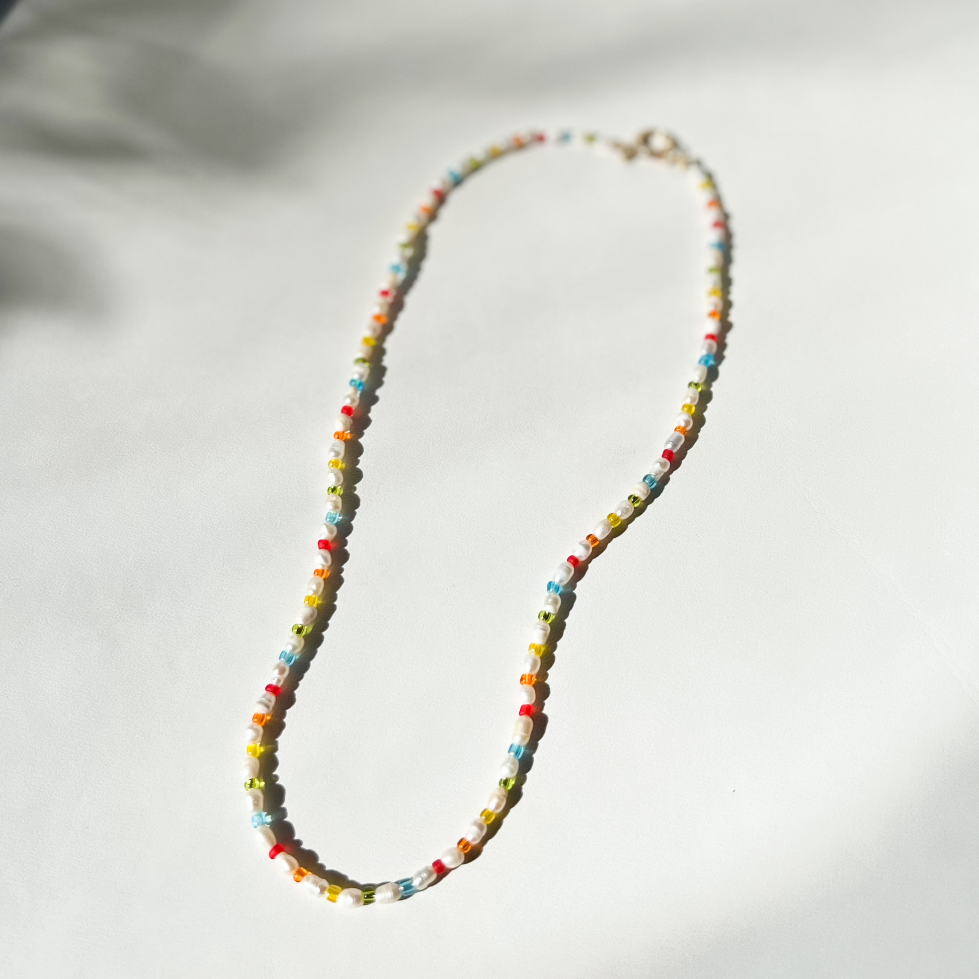 Roop Jewelry rainbow pearl necklace. Rainbow aesthetic jewelry. Spring 2022 aesthetic. Summer 2022 aesthetic. Pearl necklace in Oakland, Ca.